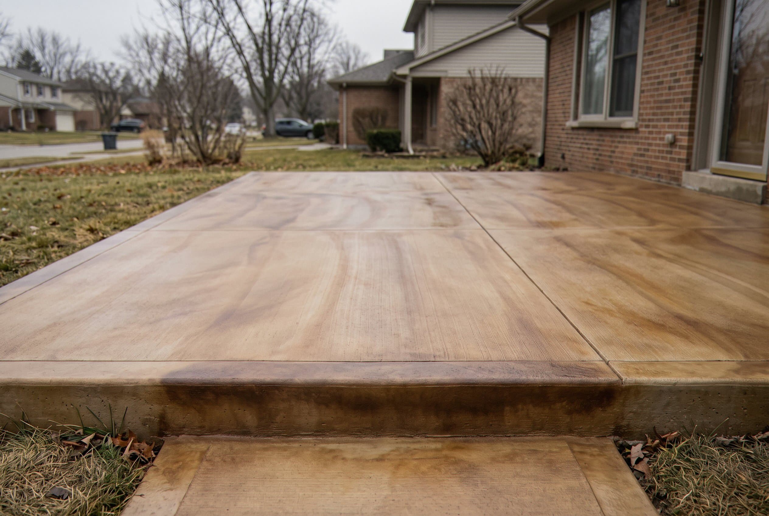 Driveway stained with a soft wood-grain style pattern